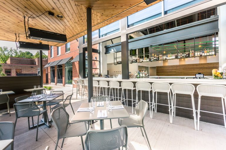 outdoor patio with bar, wood paneled ceiling, tables and outdoor ceiling heaters