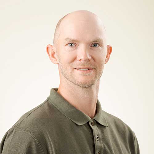 Headshot of male General Superintendent wearing a green polo shirt