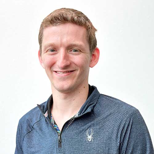 Headshot of a male electrical engineer wearing a blue sweater