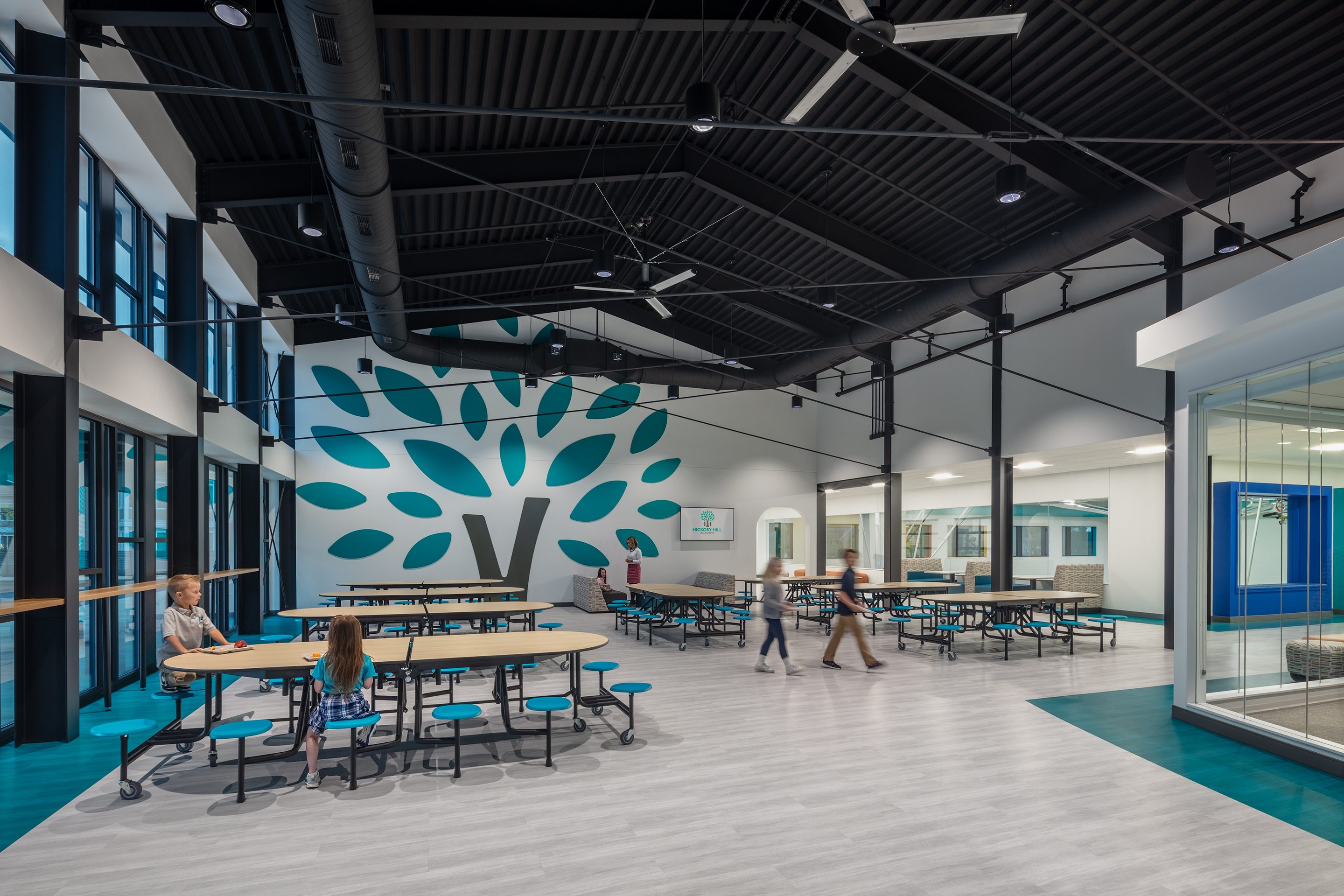 Photo-Cafeteria entry featuring a hickory tree mural with exposed black ceilings