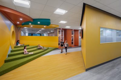 Photo-Students enjoying the corner seating in hallway with students walking by