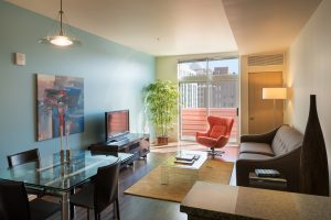 306 Main Apartments Living space with dark wood floors, light blue accent wall and dining area