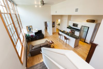 view from staircase looking down into open concept living and kitchen space