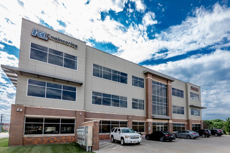 A modern three-story office building with large windows and brick accents.