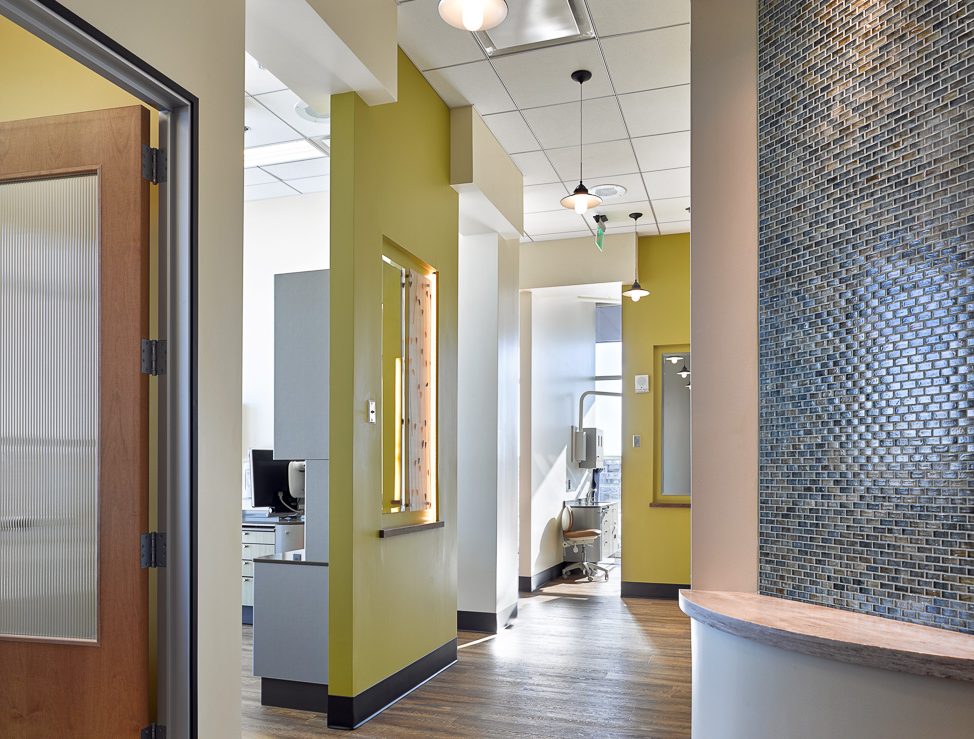 Dental Clinic hallway with curved wall and open entrances to Dental Operatories