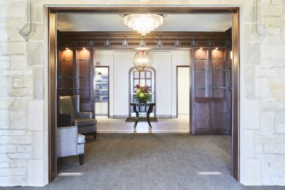 Country Club Entrance with wood panels, carpet, and impressive lighting