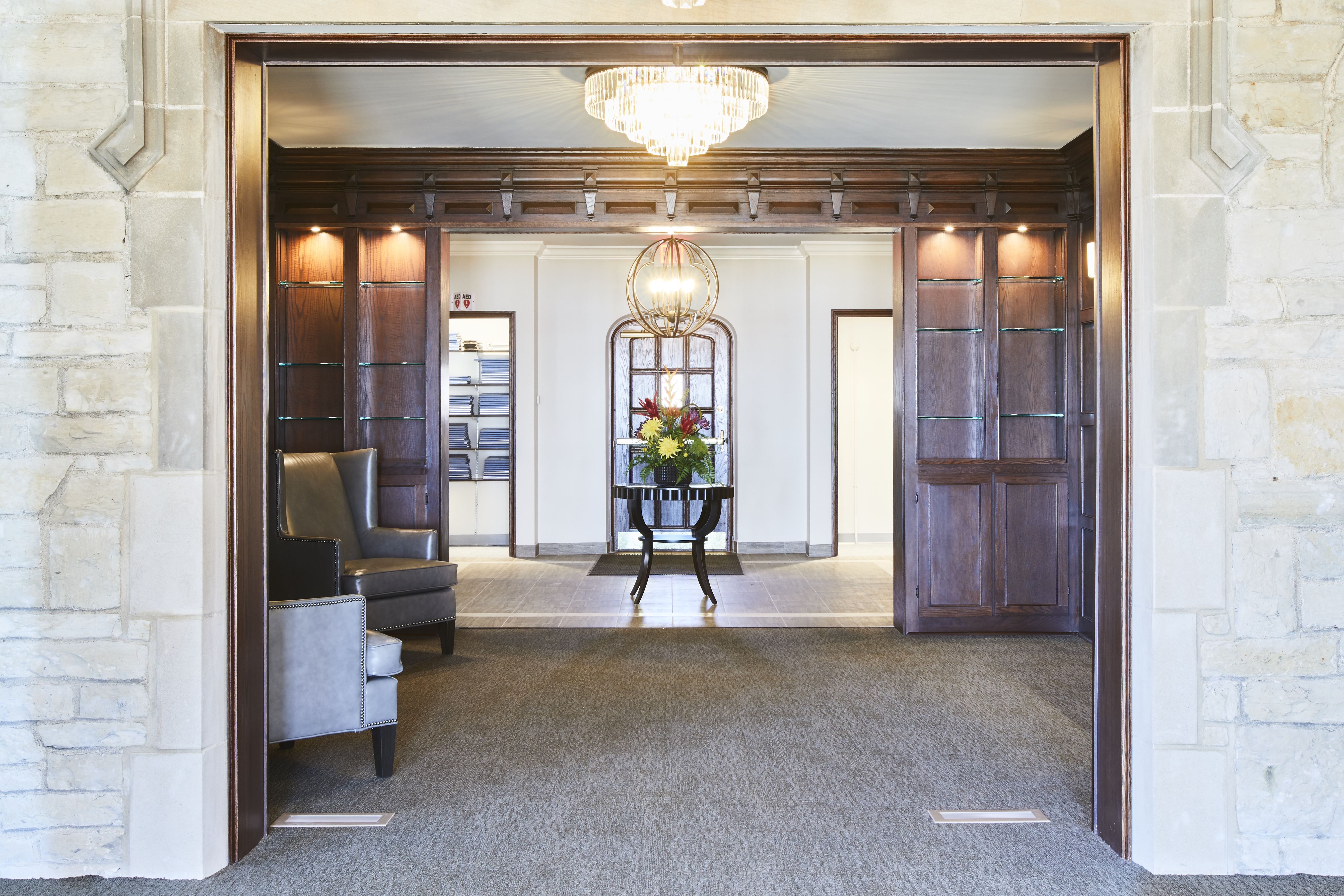 Country Club Entrance with wood panels, carpet, and impressive lighting