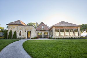 Exterior shot of country club that features the addition of the bar and lounge area with large amount of windows