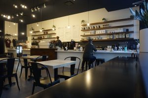 Espresso bar with open shelving, stools and cash register