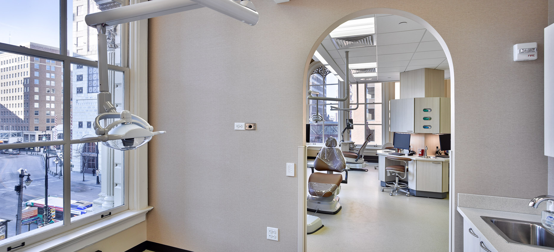 Floor to ceiling window with arched entry view into dental operatory