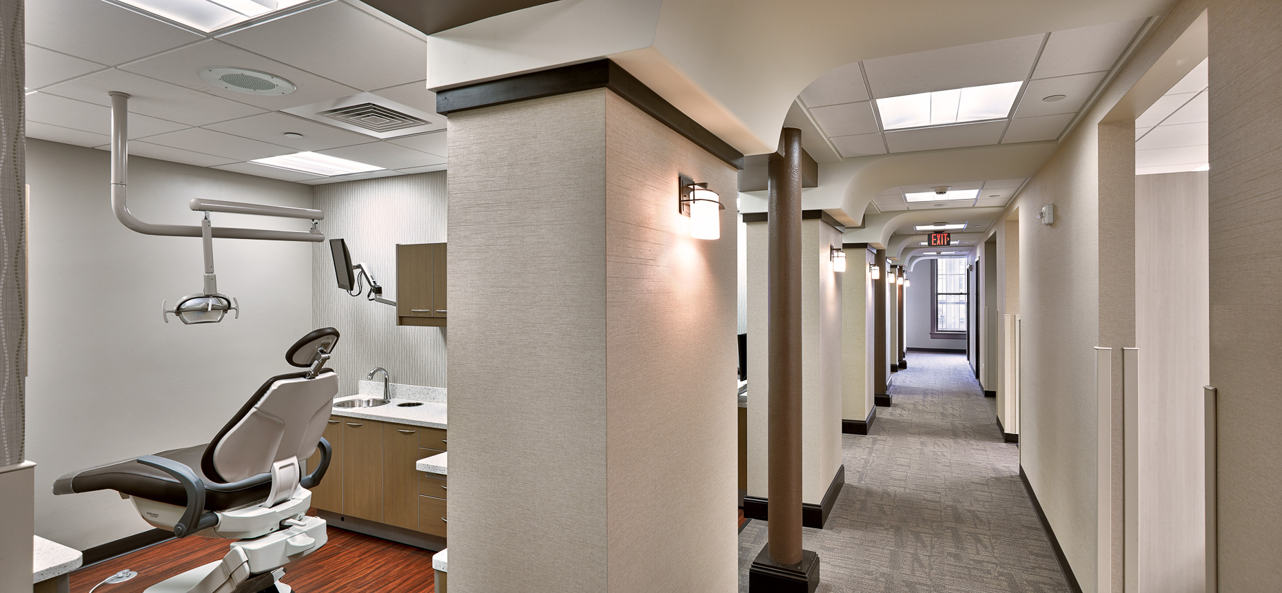 Dental office hallway with arched ceilings and look into dental operatory