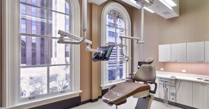 Private Dental operatory space with arched window and brown leather chair