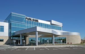 Show thumbnail preview Modern commercial building with large glass windows. The structure features a contemporary design with a combination of stone and metal elements.