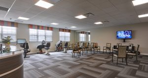 Exercise room with patterned carpet, windows and exercise equipment