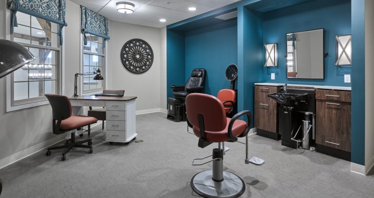 senior living facility salon with teal colored accent wall, and burnt orange seating