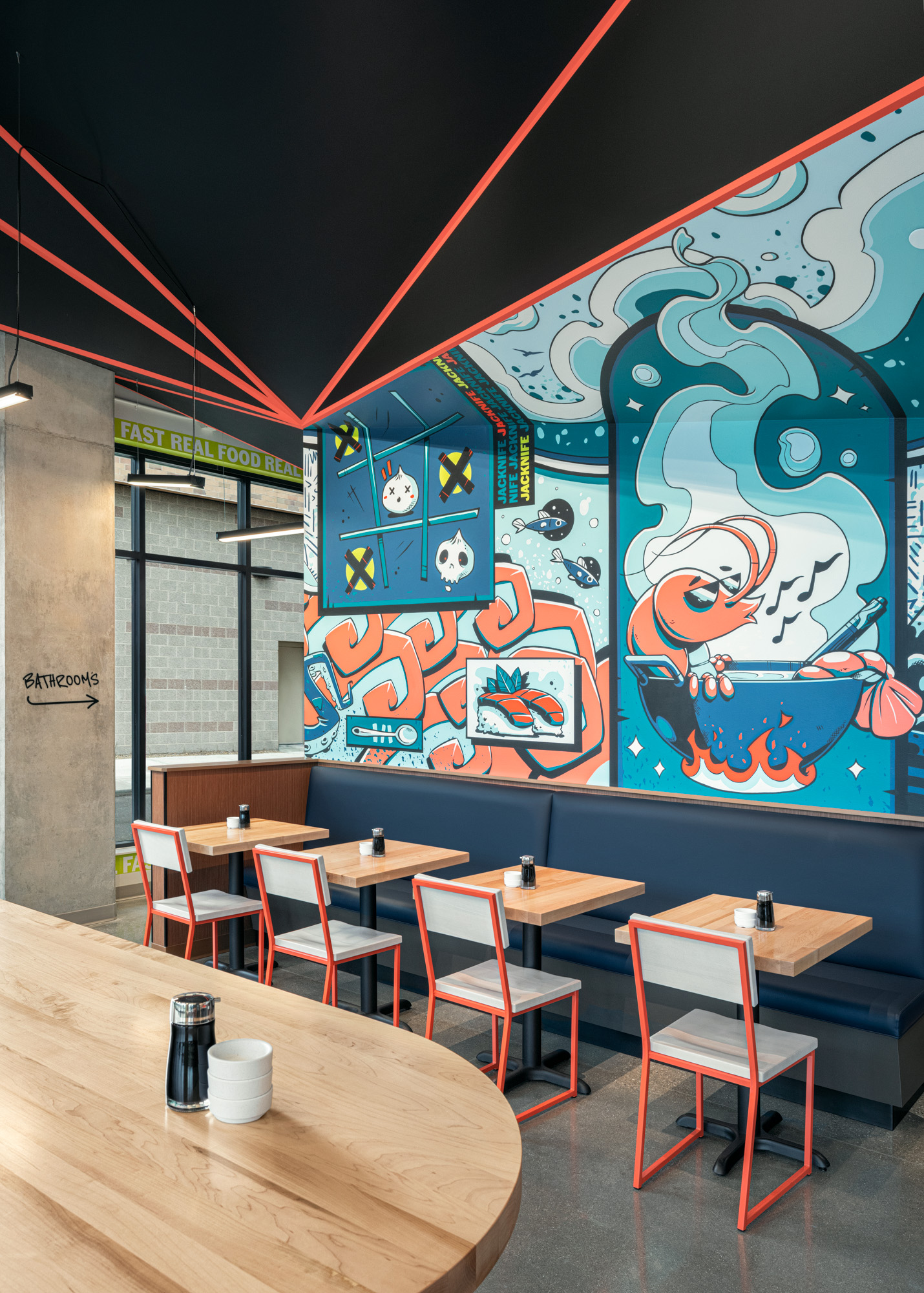 Sushi Restaurant booth seating, concrete flooring and mural wall with orange and blue accents