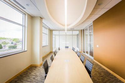 office conference room with long wood table, and oval accent ceiling