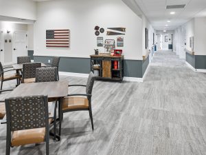 Hallway with dark gray walls, and common area with table and chairs