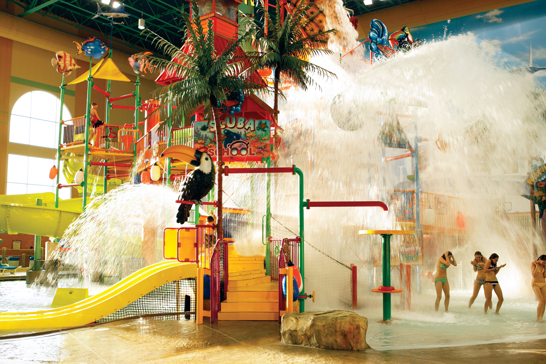 Water park slides with dump bucket pouring water over the jungle gym