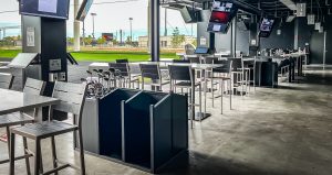 Golf bay with high top tables for food and monitors for game play