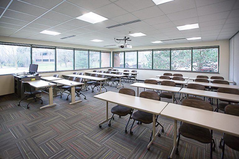 View from front of classroom featuring student seating, and expansive bright windows