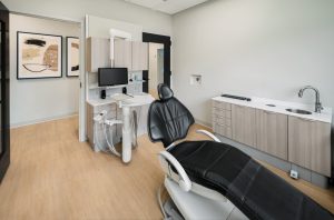 Dental operatory with black leather chair, sink and dental equipment