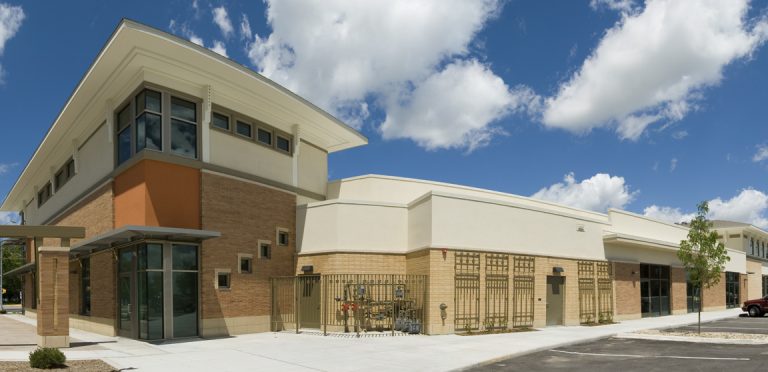 A modern two-story commercial building with large windows and beige exterior