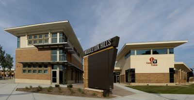 A modern brick and glass building complex with a large sign in front reading "Middleton Hills."