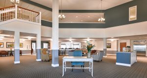 interior photo of entrance to senior living facility with high ceilings and dark green walls on the second story