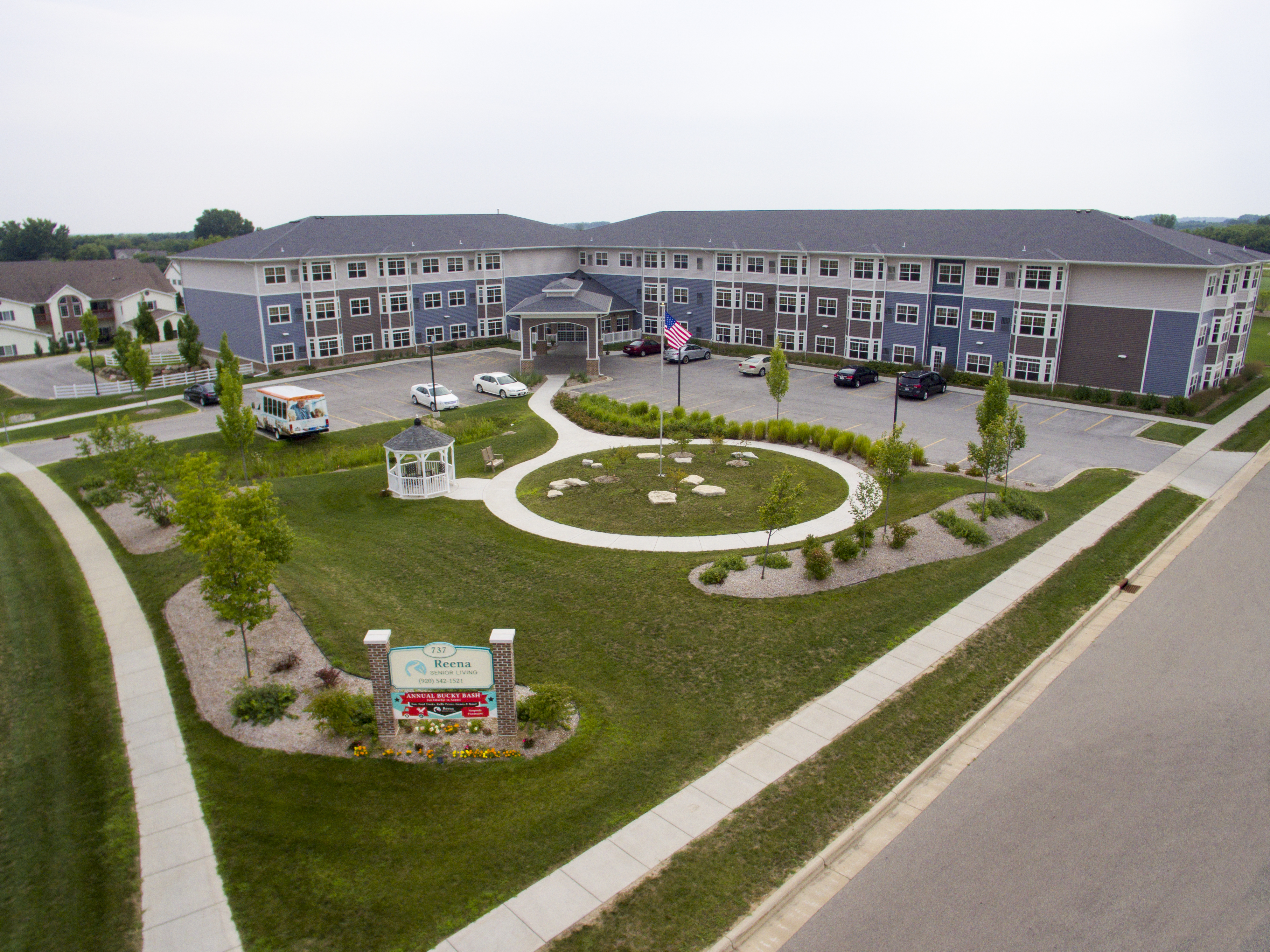 Senior Living aerial showing the entire front of the building including a circle walking path