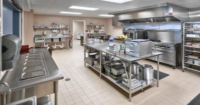 Senior living industrial kitchen with stainless steel equipment and island