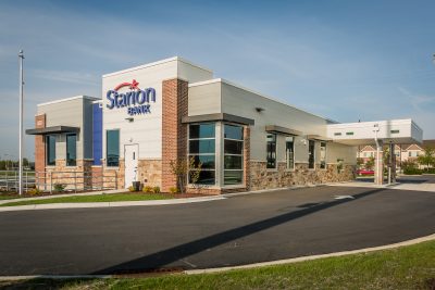 A modern bank building with a flat roof and a mix of brick and stone exterior, with large windows and a drive-thru.