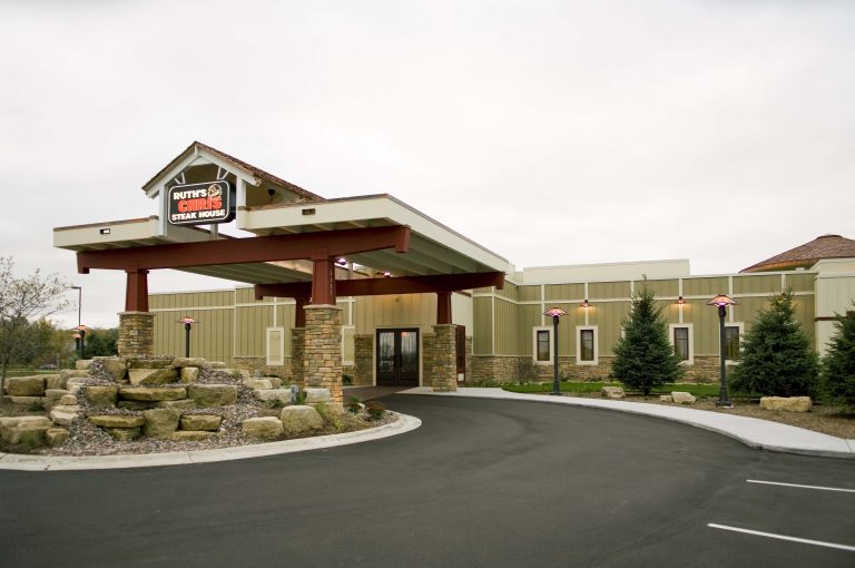 Exterior of Restaurant with a round drive up covered entrance, stone and wood accents