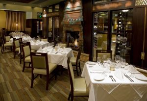 Interior of Steak House with a fireplace, tables and wine storage