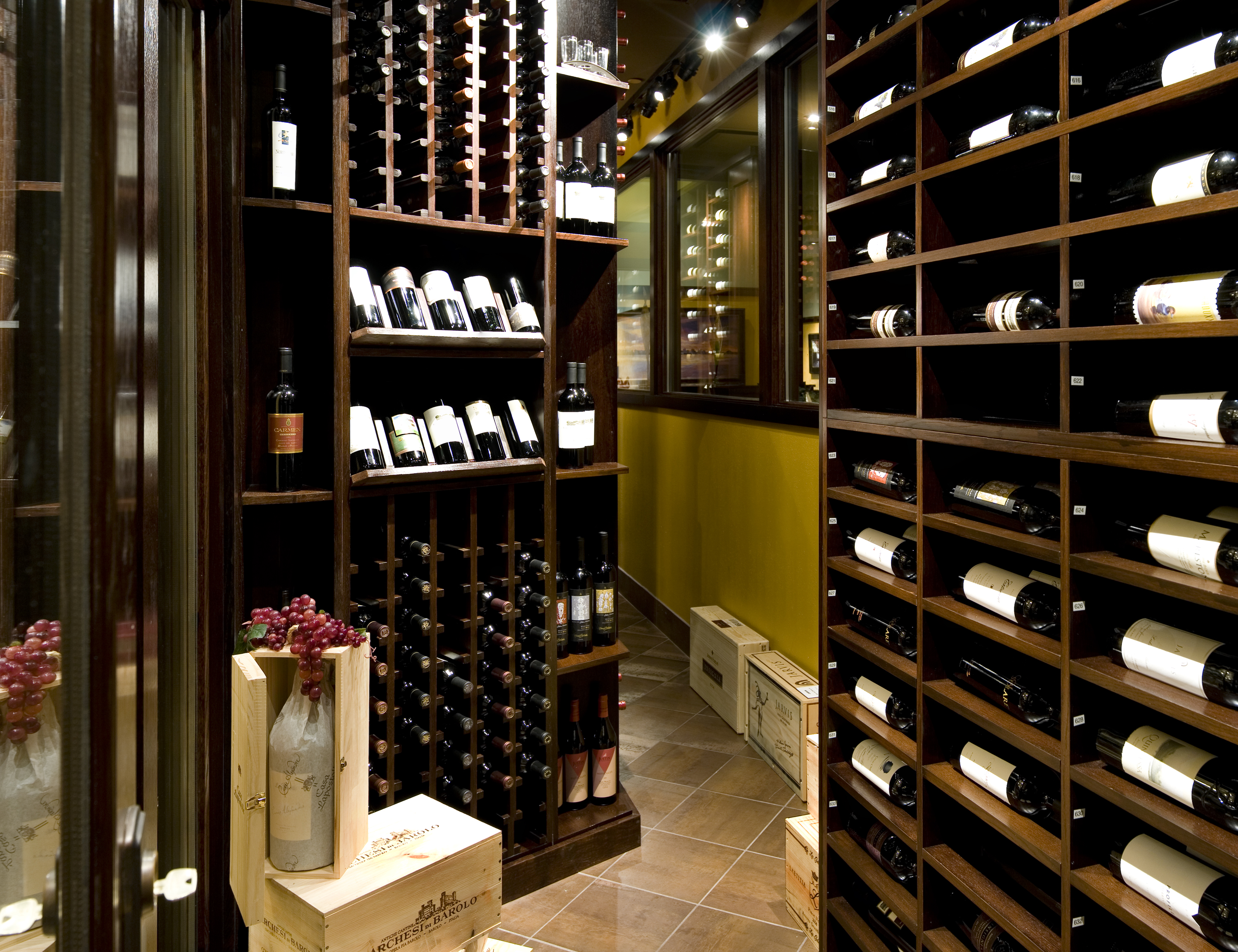 Dark wood cabinets storage the wine bottles in this wine cellar