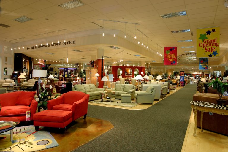 A well-lit furniture store featuring various sofas, armchairs, and tables arranged in displays.