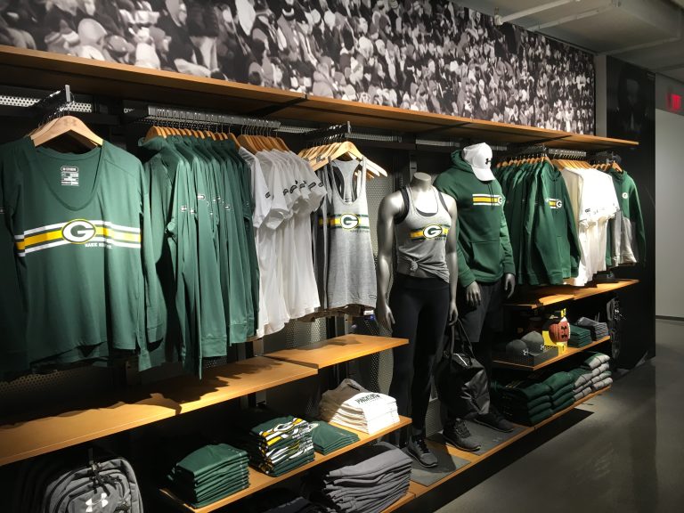 A sports merchandise store display, features green and white clothing