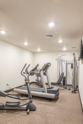 fitness center with low carpeted floors, white walls, and exercise equipment