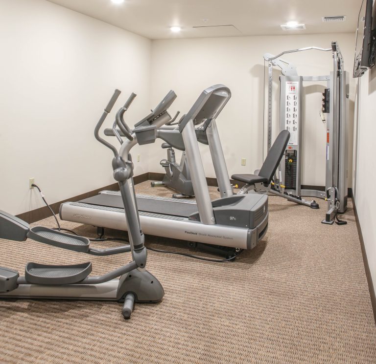 fitness center with low carpeted floors, white walls, and exercise equipment