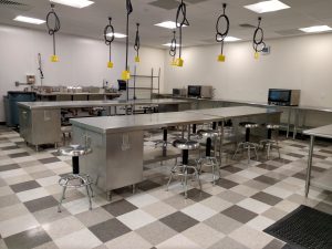 College lab space with bright lights, electrical plug ins and stainless steel tables and stools