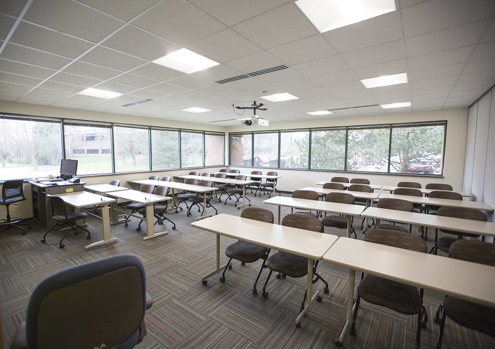 View from front of classroom featuring student seating, and expansive bright windows