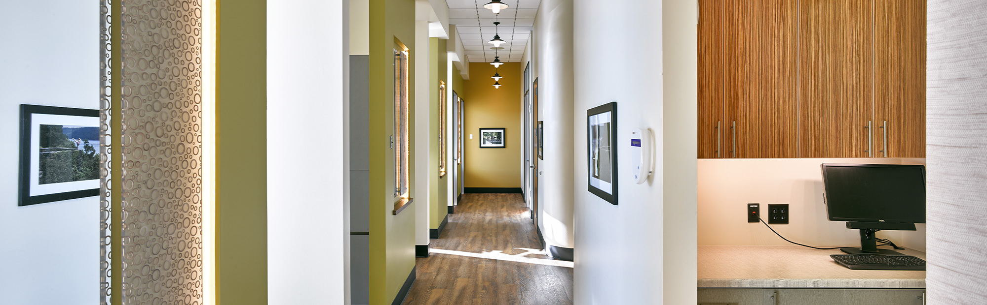 Dental Clinic hallway with yellow accent walls, wood flooring and entrances to dental operatories