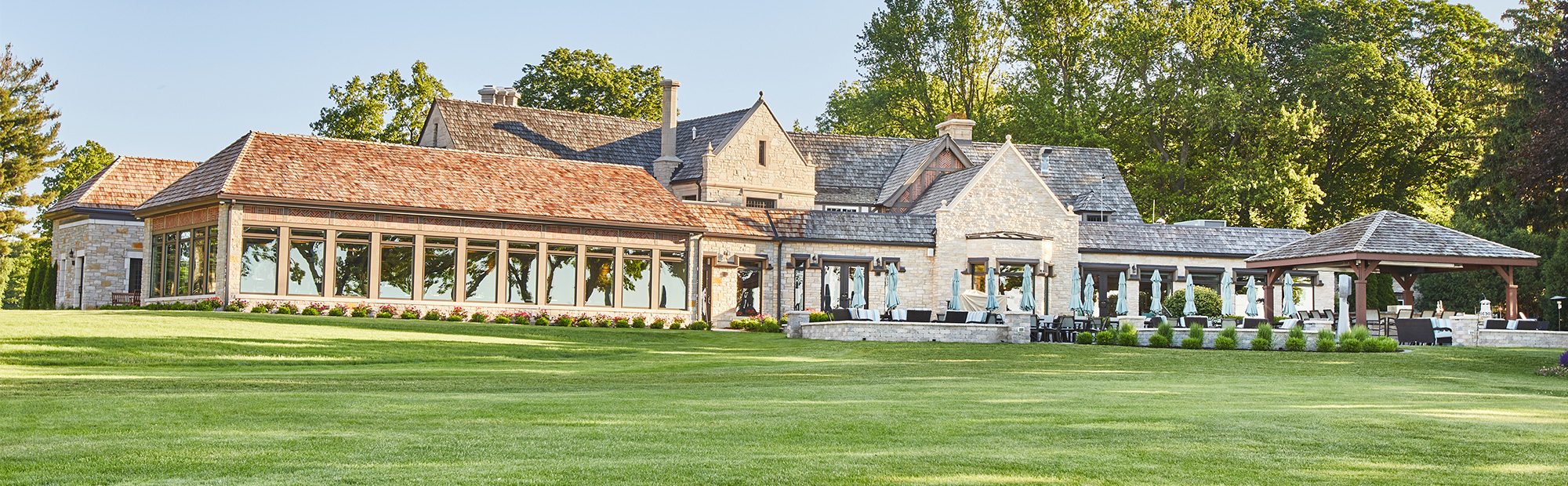 Exterior shot of country club that features the addition of the bar and lounge area with large amount of windows