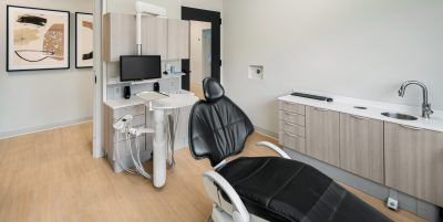 Dental operatory with black leather chair, sink and dental equipment