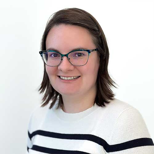 Headshot of a female architectural technician wearing a white and black striped sweater.