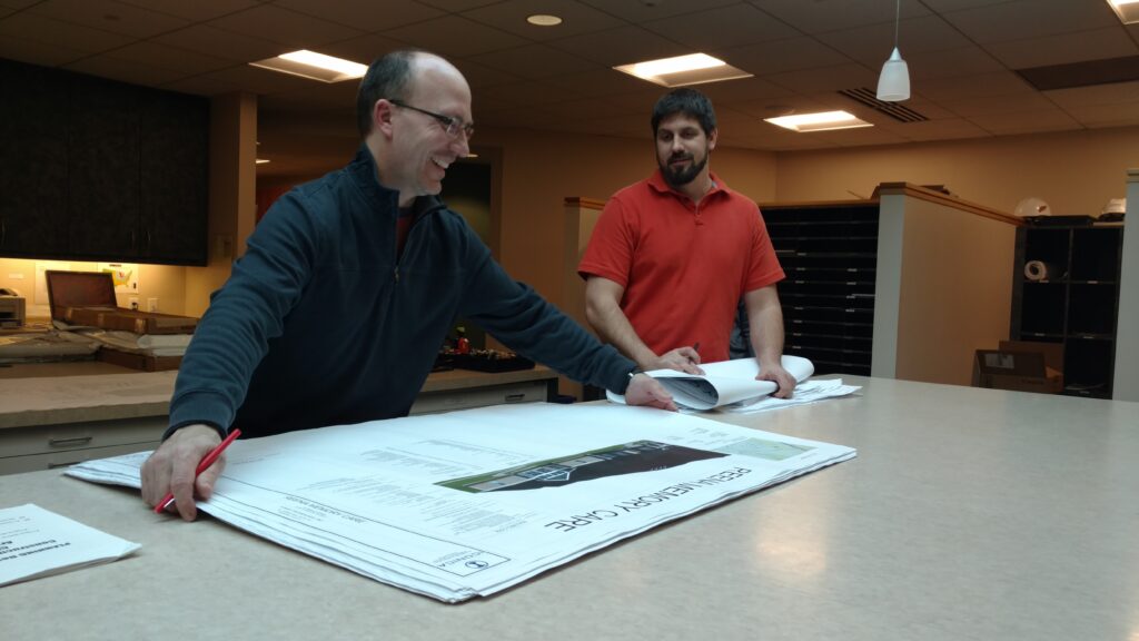 Architect at Iconcia looking over design plans on a large table