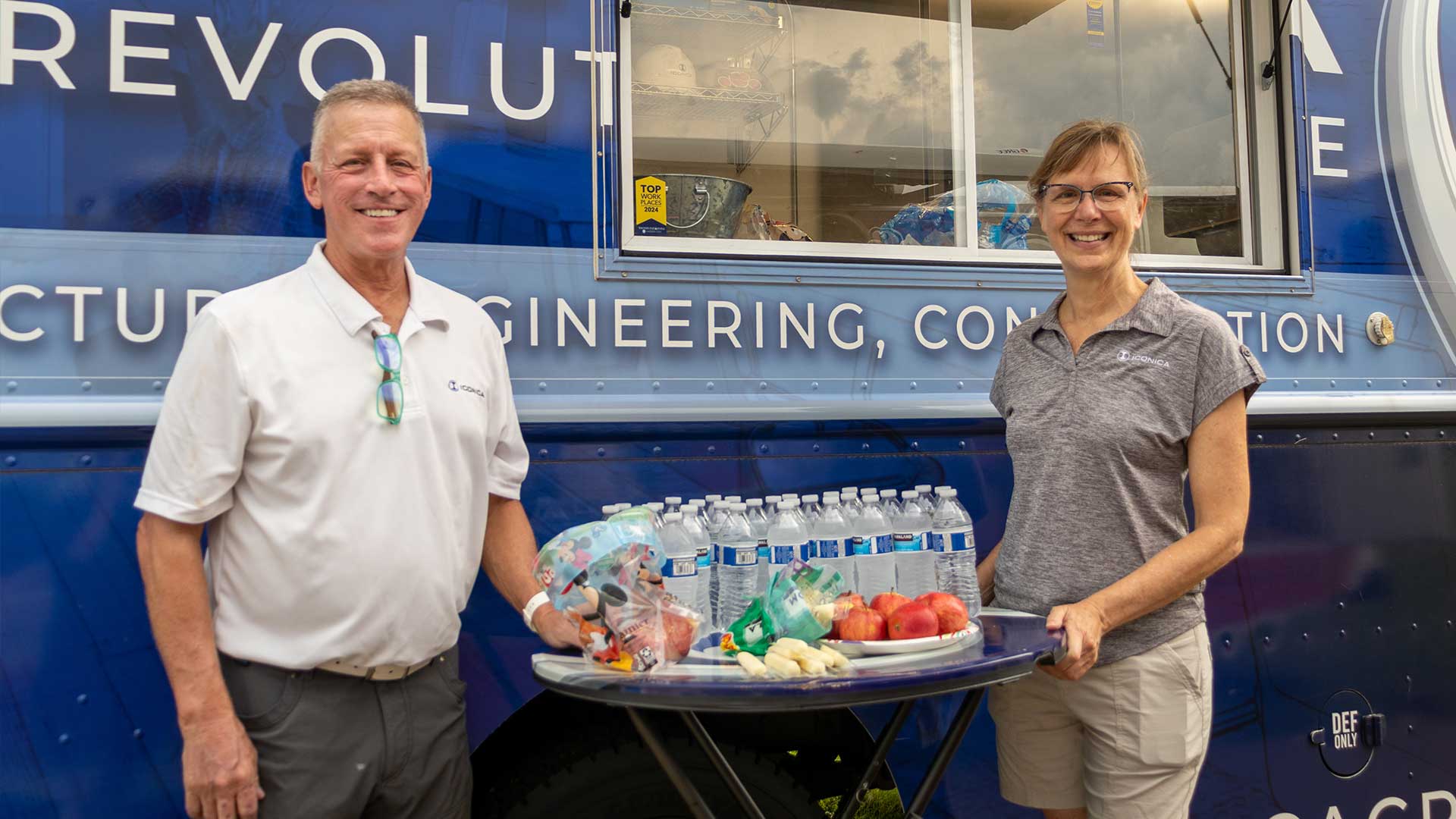 Two Iconica employees in front of the food truck smiling