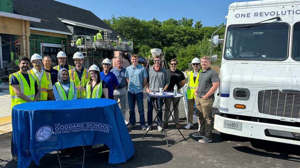 Iconica team and partners gather in front of The Goddard School construction site with the ACE food truck.