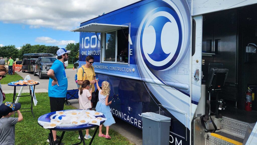 photo of food truck with line of people waiting to get food