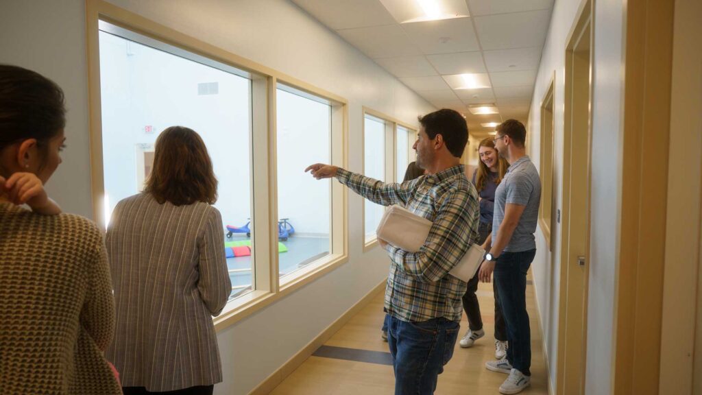 Iconica architects looking through window at the gym
